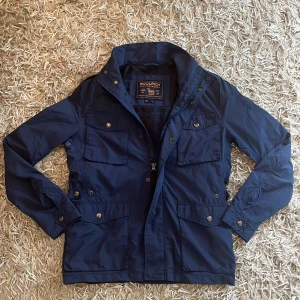 Woolrich fieldjacket: S - Säljer en väldigt fin fieldjacket ifrån Woolrich, jackan är i väldigt fint skick utan skavanker. Jackan är i storlek S och sitter som S. Nypris ligger på 6500kr ungefär. Vid fler frågor är det bara att höra av sig😊✅