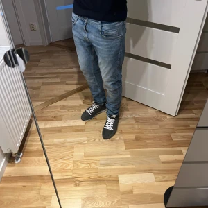 Ljusblå jeans från Mustang - Säljer ett par ljusblå jeans från Mustang med klassisk femficksdesign och snygga kontrastsömmar. Jeansen har normal passform och raka ben, tillverkade i mjukt bomullsjeansmaterial. Perfekta för dig som gillar en avslappnad och stilren look.