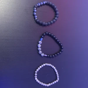 Set med tre pärlarmband i svart och grått - Säljer ett set med tre elastiska armband av runda pärlor. Ett armband har svarta lavapärlor och blanka silverfärgade pärlor, ett har mattsvarta pärlor med gråmönstrade stenar och ett är helt i gråmelerade pärlor. Perfekt för dig som gillar stilrena accessoarer. Om du vill köpa någon separat så är det bara att skriva. 