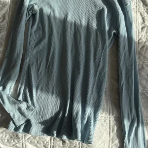 Ljusblå ribbad långärmad tröja S - Superskön ljusblå långärmad tröja från Freequent i ribbat material. Enkel och stilren modell som passar perfekt till jeans eller kjol. Mjuk och stretchig känsla, perfekt för lager-på-lager under kyligare dagar.