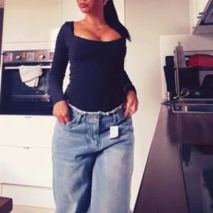 Baggy jeans - Säljer ett par ljusblå baggy jeans från Boohoo, fransad kant upptill. Modellen är loose fit och har klassiska fem fickor samt knapp och dragkedja framtill. 
