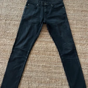 Svarta jeansbyxor Tiger of sweden 28/32 - Svarta jeansbyxor från tiger of sweden i modellen pistoler . Klassisk femficksdesign med smal passform och raka ben. Jeansen har knapp och dragkedja i midjan samt bälteshällor. Perfekt för dig som gillar stilrena och mörka jeans. Skicka prisförslag!.