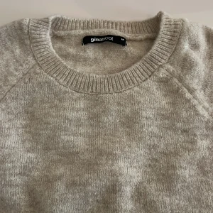 Beige stickad tröja från Gina Tricot - Mysig beige stickad tröja från Gina Tricot med rund halsringning och trekvartsärmar. Tröjan har en loose passform och är perfekt för lager-på-lager. Enkel och stilren design som funkar till allt. Använd en gång 