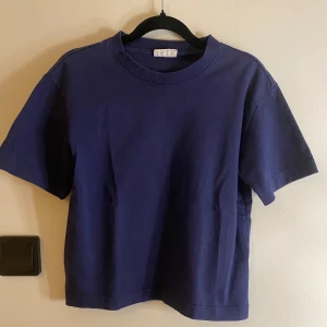 Mörkblå t-shirt i bomull - Säljer en enkel och stilren mörkblå t-shirt med rund hals och korta ärmar. T-shirten är gjord i mjuk bomull och har en klassisk passform som funkar till det mesta. Perfekt för dig som gillar basic och cleana plagg.