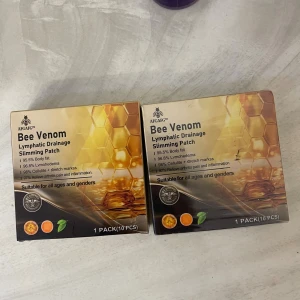Bee Venom Lymphatic Drainage Patch - Bee Venom Lymphatic Drainage Slimming Patch från AFGAFG, 1 pack med 10 st plåster. Förpackningen är guldfärgad med honungskakemönster och innehåller ingredienser som bi-gift, svartpepparextrakt, isväxtextrakt, pepparmyntsmentol, ingefära och mariatistel.