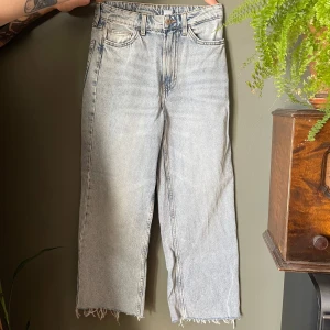 Wide ultra high waist jeans &Denim - Ljusblå jeans från &Denim med ultra hög midja och breda ben. Modellen är wide fit och har råa, fransiga benslut för en avslappnad vibe. Klassisk femficksdesign och tillverkade i jeansmaterial. Perfekta för dig som gillar en trendig och bekväm look. Benen är avklippta och är ca 93 cm långa från linningen. 