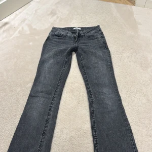 Grå bootcut jeans från Gina Tricot  - Snygga grå jeans från Gina Tricot i storlek 36. Modellen har klassisk femficksdesign, dragkedja och knapp framtill samt en lätt utsvängd bootcut-passform. Jeansen är tillverkade i mjukt denimtyg och har en cool tvättad look.