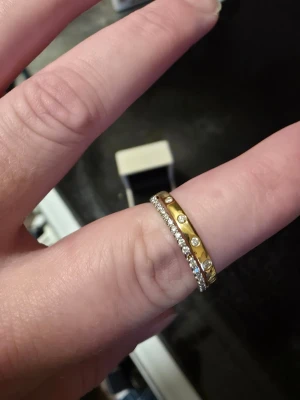 18 K vigselring/förlovningsring  - 18 k vigselring/förlovningsring.  Köpt på albrekts guld för 6499 kr. Skulle ha som vigselring men bestämde oss för en annan. Saknas 2 stenar och gjorde redan vid köp. 