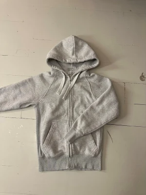 Russemerch zip hoodie Grå - Säljer denna russe zip hoodie i storlek S. Har använts ett fåtal gånger. Tjejen på sista bilden är 165cm lång. Nypris ligger just nu på ca750kr jag säljer denna för 500kr. Har ni frågor eller funderingar är det bara att skriva och fråga. Mvh Liam!😁