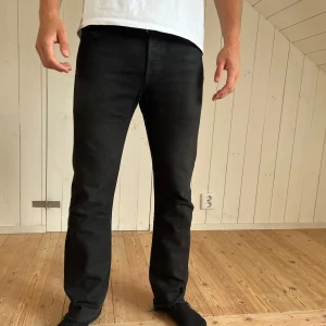 Svarta Levi's 501 jeans W30 L32 - Svarta Levi's 501 jeans med klassisk rak passform. Bra denimtyg som håller hur länge som helst och dessa är inte använda! Har kvar den ikoniska läderpatchen bak i midja! 