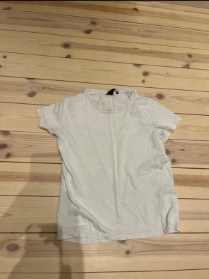 Vit basic t-shirt från Lindex - En enkel vit t-shirt från Lindex Basic med rund hals och korta ärmar. Modellen är klassisk och passar perfekt till jeans eller shorts. Materialet är mjukt och skönt bomull som andas bra. Perfekt för dig som gillar en clean och stilren look.