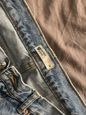 Ljusblå raka jeans från Perfect Jeans - Säljer ett par ljusblå jeans från Perfect Jeans i rak modell. Klassisk femficksdesign, normal passform och råa kanter nertill för en avslappnad vibe. Jeansen har snygga kontrastsömmar och är tillverkade i slitstarkt denimtyg.