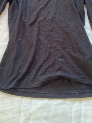 Svart långärmad topp i bomull - Enkel svart långärmad topp från gina tricot , öppen slits vid armarna och urringad.