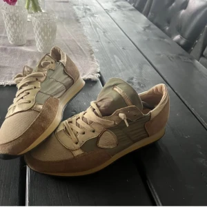 Philippe modell  - Snygga sneakers i beige och grönt med snörning. Skorna har en kombination av mocka och syntetmaterial, vilket ger dem en stilren look. Perfekta för en avslappnad stil.