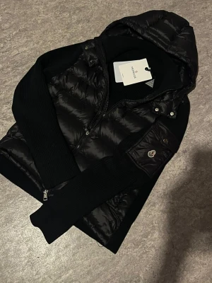 Svart cardigan moncler med NFC+QR - Säljer en svart moncler cardigan som jag har använt super lite eftersom att jag har nu köpt en ny vinter jacka så jag försöker sälja denna