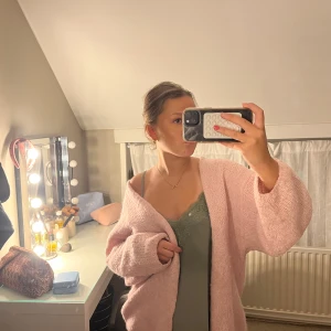 Ljusrosa stickad kofta från Lindex - Supermysig ljusrosa stickad kofta från Lindex i storlek M/L. Koftan har en loose passform, långa ärmar och är öppen framtill utan knappar. Perfekt att slänga över en topp för en chill look. Materialet är mjukt och fluffigt, vilket gör den extra skön. Använt väl💕lite smutsig vid ärmarna men tyvärr inget som går bort i tvätten 