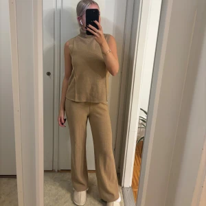 Beige set från Zara  - Säljer ett par beige stickade byxor med matchande tröja från Zara i storlek S.