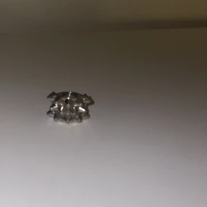 Silvrig ring med nitar från Edblad - Cool och chunky ring från Edblad i silverfärgad metall med flera spetsiga nitar runt hela ringen. Perfekt statement piece för dig som gillar edgy och unik stil. Ringen är bred och har en riktigt tuff design som sticker ut.