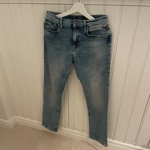Replay ljusblå jeans straight fit - Snygga ljusblå jeans från Replay med klassisk femficksdesign och raka ben. Jeansen har Replay-logga på bakfickan och läderpatch i midjan. De är tillverkade i slitstarkt denim och har normal passform med knapp och dragkedja framtill.