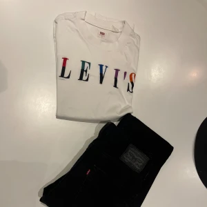 Långärmad vit T-shirt - Snygg vit t-shirt från Levi's med stort, färgglatt logotryck på bröstet. Klassisk rund hals och korta ärmar. Perfekt för dig som gillar stilrena plagg med en twist.