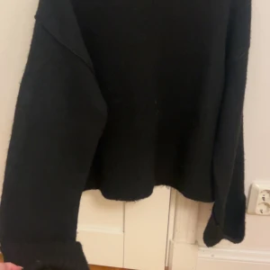 Svart stickad tröja Gina Tricot XS - Svart stickad tröja från Gina Tricot i storlek XS. Tröjan har lång ärm med breda ribbade muddar och en loose passform. Perfekt för dig som gillar enkel och stilren look med lite oversized känsla.