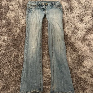 Ljusblå lågmidjade jeans - Snygga ljusblå bootcut jeans från Red Herring med klassisk femficksdesign och broderade detaljer på bakfickorna. Jeansen har låg midja. Lånade bilder 💓💓 Storlek XS/S och midjemått tvärs över är 37 och innerbenslängd 78cm