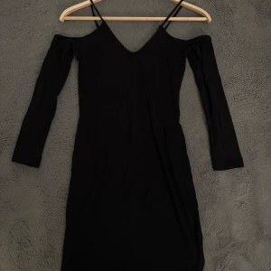 Svart offshoulder klänning H&M - Svart klänning från H&M med offshoulder-design och smala axelband. Långärmad och figurnära passform. Använd endast två gånger så är som ny! Skriv för fler bilder🥰