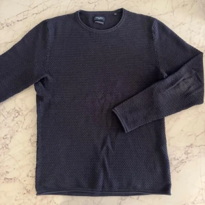 Mörkblå grovstickad tröja Jack & Jones - Säljer en mörkblå stickad tröja från Jack & Jones i storlek S. Tröjan har ett grovt stickat mönster och rund halsringning. Perfekt för dig som gillar enkel och stilren design med lite struktur. Passar dig som vill ha en klassisk look. Perfekt skick. 