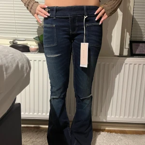 Mörkblå bootcut low rise jeans från Gina Tricot - Slutsålda, snygga mörkblå low rise jeans i modellen ” pleated flare jeans”. De har slitningar på låren och knäna. Storlek S och passar 34/36 🥰 Nypris 360kr, tar emot bud 💞💝