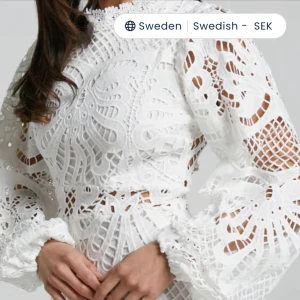 Vit spetsklänning med volang - Superfin vit kort klänning i spets med volang nertill och långa puffiga ärmar. Klänningen har vackra broderade detaljer och genombrutet mönster som ger en romantisk vibe. Perfekt för dig som vill sticka ut med en unik och feminin look. Säljer för jag hittat en annan studentklänning. 