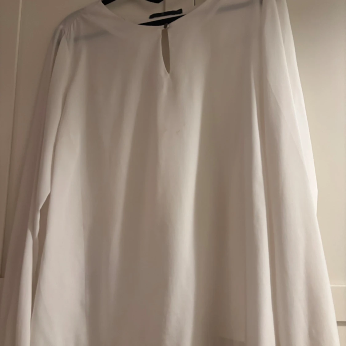 Vit blus med knappdetaljer