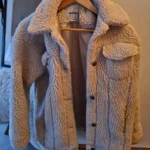  Teddyjacka från Monki - Säljer denna mysiga teddyjacka från Monki i beige färg då jag äger två teddyjackor. Storlek XXS, dock stor i stoleken. Skulle uppskatta XS/S (jag brukar ha S i jackor). 