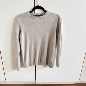 Beige kashmirtröja från Oscar Jacobson - Snygg beige stickad tröja från Oscar Jacobson i kashmir. Klassisk rund halsringning och ribbade muddar vid ärmslut och nederkant. Perfekt för lager-på-lager och passar till allt. Tillverkad i Italien. Ända problemet är att tröjan är dåligt tvättad så skulle nog säga att den passar bäst på en storlek S. Men annars är den i fint skick. Pris kan diskuteras! 