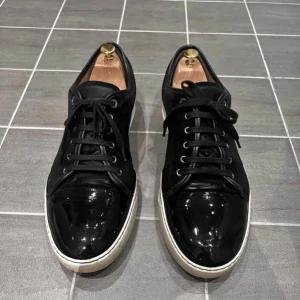 Lanvin skor - Säljer ett par svarta sneakers från Lanvin. Sista bilden är med blixt därför de ser ut att vara gråa😊fråga på om behövs! defekter visas på bilden. inget OG med! pris kan diskuteras.