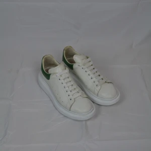 Alexander McQueen skor - Ett par vita Alexander McQueen med mörkgrön kappa. Skorna är i storlek 44 och är i väldigt bra skick.                                                                          Vid frågor eller funderingar är det bara att höra av sig, och kom ihåg, alltid 14 dagars ångerrätt hos oss på Revalo!