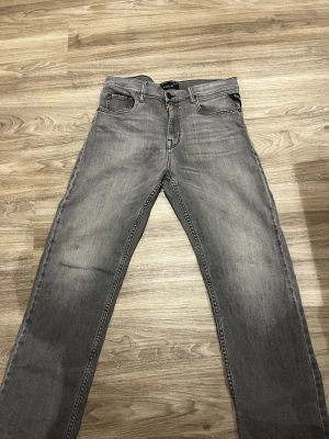 Replay grå jeans Thad straight fit - Säljer ett par grå jeans från Replay, modell Thad. Jeansen har klassisk femficksdesign, raka ben och normal passform. Snyggt tvättad grå färg med diskreta slitningar. Perfekta för dig som gillar stilrena och bekväma jeans.