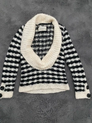 Randig kofta från By Malene Birger - En väldigt unik och vacker stickad tröja från ”BY MALENE BIRGER” säljer jag till ett bra pris. Det är en svart- och vitrandig tröja med en stor, vit sjalkrage och dekorativa knappar vid ärmsluten. Det står inte vilken storlek det är på tröjan men tröjan är stretchig så passar nästan vem som. Pris kan diskuteras.