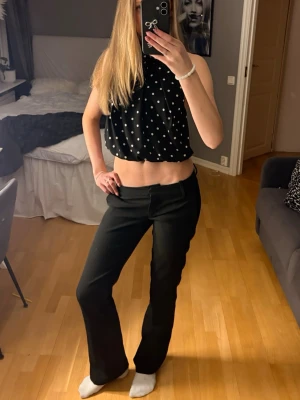 Svarta bootcut kostymbyxor BikBok - Svarta kostymbyxor från BikBok i storlek 34. Byxorna har bootcut-modell med raka ben och lätt utsvängda nedtill. Låg midja och hällor för bälte. Perfekta till en snygg topp eller skjorta.