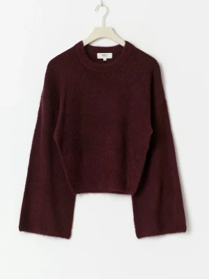 Vinröd stickad croppad tröja Gina Tricot - Mysig vinröd stickad tröja från Gina Tricot med croppad passform och vida, långa ärmar. Tröjan har rund halsringning och är gjord i ett fluffigt material som känns både trendigt och bekvämt.   Ej använd!!)