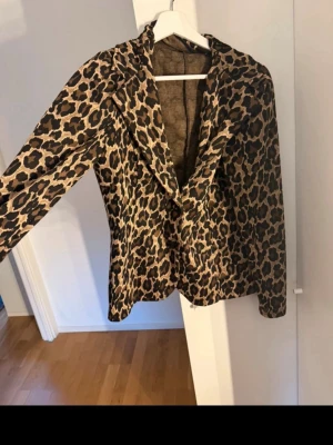 Leopardmönstrad kavaj  - Säljer en snygg leopardmönstrad kavaj från Vero Moda. Kavajen har klassisk krage, knäppning framtill och lång ärm. Färgerna går i beige och brunt med svarta leopardfläckar. 🐆