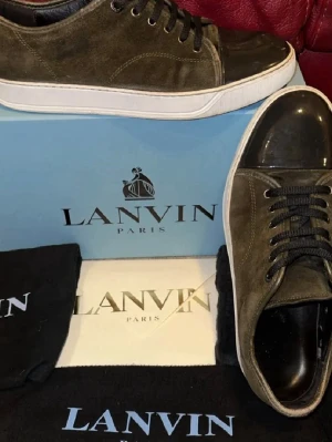 Lanvin skor - Snygga Lanvin sneakers i olivgrön mocka. Kommer med extra snören och allt som är på bilden. Ny pris ligger på 5000. Storlek Uk 10 sitter som 45 