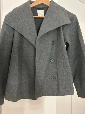 Grå kappa från Gina Tricot - Super fin jacka från Gina Young. Den är perfekt till våren och passar till alla outfits! Bara använts några gånger så inte direkt något tecken på användning!