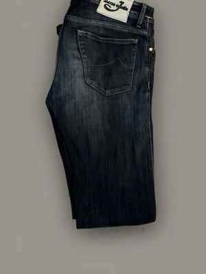 Mörkblå jeans från Jacob Cohen - Snygga mörkblå jeans från Jacob Cohen med en tvättad look. Tillverkade i mjukt bomullsmaterial med en touch av stretch för extra komfort. Storlek 32 Style 688