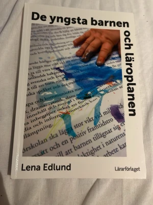 De yngsta barnen och läroplanen - Boken 'De yngsta barnen och läroplanen' av Lena Edlund ger praktiska exempel på hur förskolans läroplan kan tillämpas med de yngsta barnen. Omslaget är vitt med en färgglad illustration och text. Perfekt för dig som pluggar pedagogik eller jobbar inom förskola. Nyskick inuti, nån repa utompå 