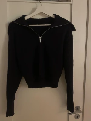 Mörkblå  ziptröja från Gina Tricot - Säljer en mörkblå långärmad ziptröja från Gina Tricot, basically basics-kollektionen. Tröjan har en bred krage och dragkedja framtill. Har en liten skada på ena axeln.