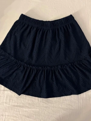 Mörkblå volangkjol med broderi - Mörkblå kjol, köpt på Nellys hemsida 2022. Använd fåtal gånger💕