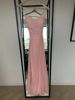 Ljusrosa balklänning - Säljer denna ursnygga balklänning från JJ’s House!! 🤍 Endast använd en gång och i perfekt skick, inga fläckar. Storlek 34, puderrosa färg. Klänningen har snörning i ryggen som gör att passformen går att justera. Produktkod: #309805 Obs: liite längre, för att kunna ha klackar🤍Skriv för exakta mått🫶