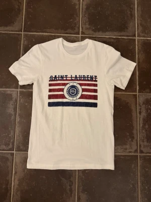 Saint Laurent t shirt  - Riktigt fet och eftertraktad saint Laurent t shirt i storlek S! Helt nytt skick! Lite osäker på äktheten eftersom lappen i nacken saknas så därför är priset just nu på 499kr nypris runt 3000kr! Tveka inte med att ställa frågor! 