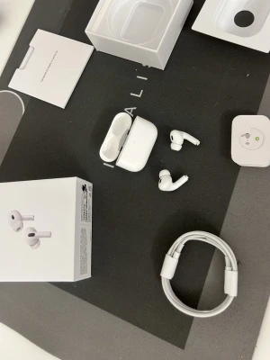 Apple AirPods Pro trådlösa hörlurar - Säljer ett par vita Apple AirPods Pro med laddningsetui och tillbehör. Snygg och kompakt design i plast, perfekt för musik och samtal. Levereras med originalkartong, laddningskabel och manual. Smidig anslutning till iPhone och andra Apple-enheter.