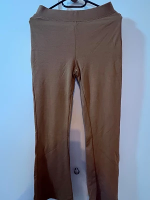 Beiga leggings med hög midja - Snygga beiga leggings med hög midja och stretchig passform. De har en enkel design utan synliga detaljer och är perfekta för en chill och stilren look. Materialet känns mjukt och bekvämt mot huden.